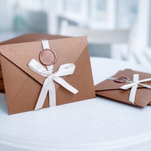 bronze invitation envelope with ribbon and wax seal of gift certificate or wedding card